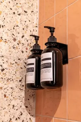 two bottles of soap are hanging on a wall at Cunabu Urbano in Rome