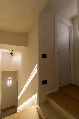 an empty hallway with a white door and stairs at Cunabu Urbano in Rome