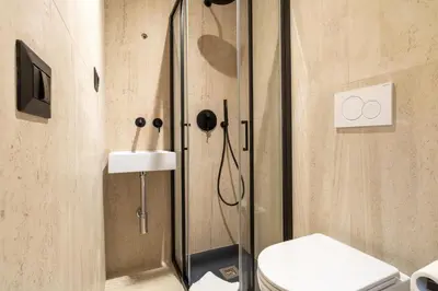 a bathroom with a shower with a toilet and a sink at Cunabu Urbano in Rome