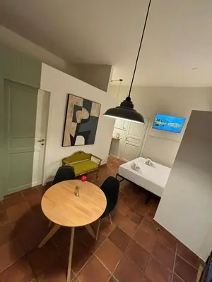 a living room with a table and a bed at Flaminia's House San Pietro Station in Rome