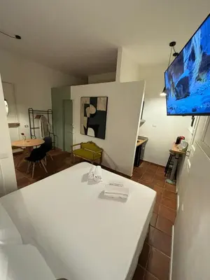 a living room with a white table and a flat screen tv at Flaminia's House San Pietro Station in Rome