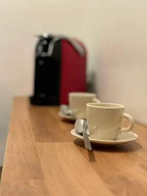 a cup of coffee sitting on a wooden table at Flaminia's House San Pietro Station in Rome