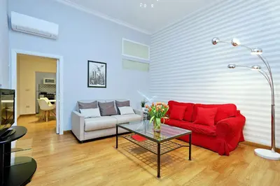 a living room with a red couch and a table at Cozy Tritone - My Extra Home in Rome