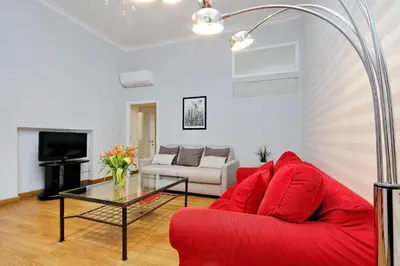 a living room with a red couch and a table at Cozy Tritone - My Extra Home in Rome
