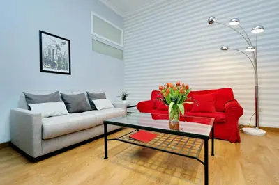 a living room with a red couch and a table at Cozy Tritone - My Extra Home in Rome