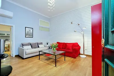 a living room with a red couch and a table at Cozy Tritone - My Extra Home in Rome