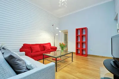 a living room with a red couch and a glass table at Cozy Tritone - My Extra Home in Rome
