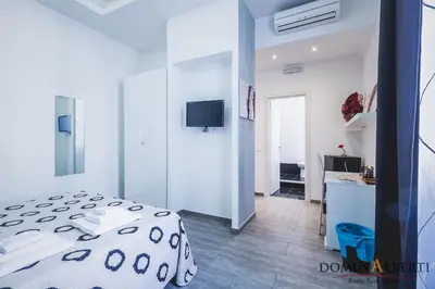 a bedroom with a bed and a desk and a television at Domus Alberti Bed & Breakfast in Rome