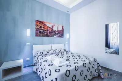 a bedroom with a white bed and a picture on the wall at Domus Alberti Bed & Breakfast in Rome