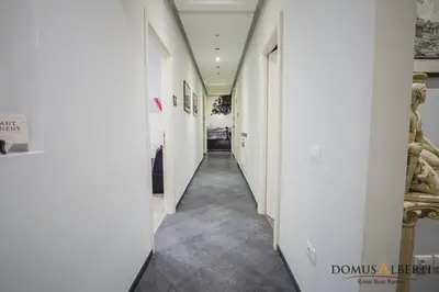 a hallway with white walls and carpeted floors at Domus Alberti Bed & Breakfast in Rome