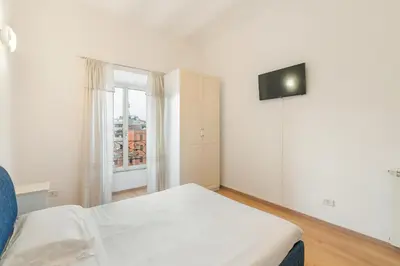 a white bedroom with a bed and a window at Termini Station Lightsome 3BR Apartment in Rome