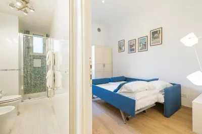 a bedroom with a blue bed and a bathroom at Termini Station Lightsome 3BR Apartment in Rome