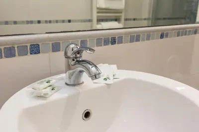a white bathroom sink with a faucet and a mirror at Termini Station Lightsome 3BR Apartment in Rome