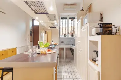 a kitchen with a counter with wine glasses on it at Termini Station Lightsome 3BR Apartment in Rome