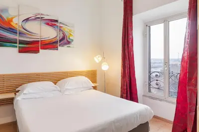 a bedroom with a white bed and a window at Termini Station Lightsome 3BR Apartment in Rome