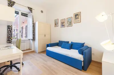 a living room with a blue couch in a room at Termini Station Lightsome 3BR Apartment in Rome