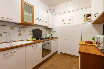 a kitchen with white cabinets and a sink at Monti Charming Amphora Apartment in Rome