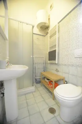 a bathroom with a white toilet and a sink at Prati House in Rome