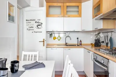 a kitchen with white cabinets and a white table at Your elegant Loft at Termini Station in Rome