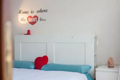 a bed with a heart sign on the wall at Vatican R-Home Savorelli in Rome