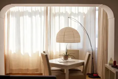 a table and chairs with a lamp in front of a window at Vatican R-Home Savorelli in Rome