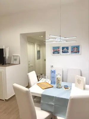 a white dining room with a blue table and white chairs at Olimpia Villa Pamphili - Centro Storico di Roma - Gianicolo Trastevere San Pietro in Rome