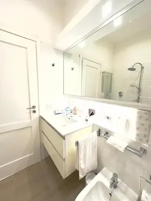 a white bathroom with a sink and a mirror at Olimpia Villa Pamphili - Centro Storico di Roma - Gianicolo Trastevere San Pietro in Rome