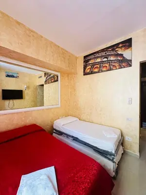 a bedroom with two beds and a tv on the wall at Termini Sunlight House in Rome