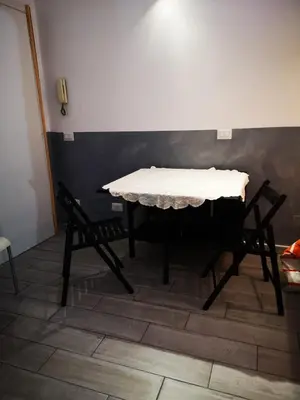 a table and two chairs in a room with a wall at Casa Manzoni in Rome