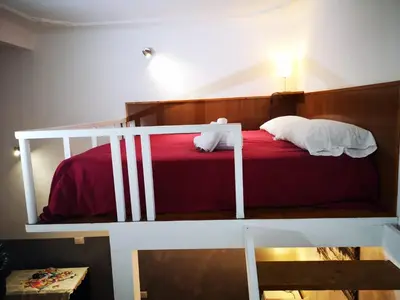 a bedroom with a bunk bed with red sheets and white pillows at Casa Manzoni in Rome