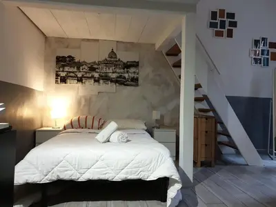 a bedroom with a white bed and a staircase at Casa Manzoni in Rome