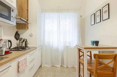 a kitchen with white cabinets and a table and a window at Bellina Suite at the Vatican in Rome
