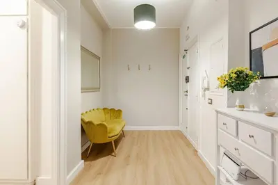 a hallway with a yellow chair in a white room at Bellina Suite at the Vatican in Rome