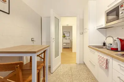 a kitchen with white cabinets and a wooden table at Bellina Suite at the Vatican in Rome