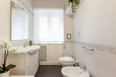 a white bathroom with a toilet and a sink at Bellina Suite at the Vatican in Rome
