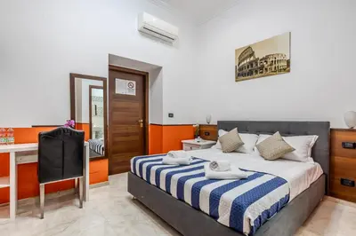 a bedroom with a bed and a desk in it at STELLA GUEST HOUSE O AFFITTACAMERE in Rome