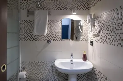 a bathroom with a sink and a mirror at STELLA GUEST HOUSE O AFFITTACAMERE in Rome