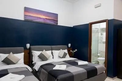 a bedroom with two beds and a blue wall at STELLA GUEST HOUSE O AFFITTACAMERE in Rome