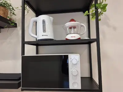 a black shelf with a blender and a microwave at Peaceful 2 Bedrooms with patio, near Metro A in Rome