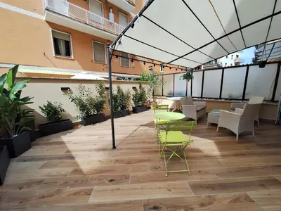 a patio with chairs and tables on a building at Peaceful 2 Bedrooms with patio, near Metro A in Rome
