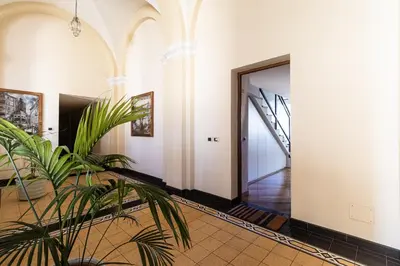 a hallway with a door and a plant at [Trastevere Lux* * * * *] - Roma Centro Storico in Rome