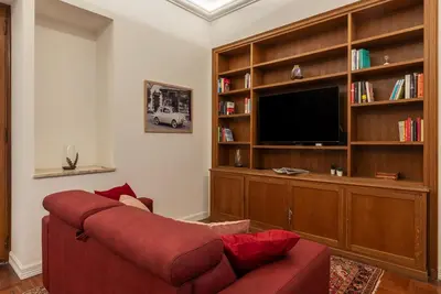 a living room with a red couch and a flat screen tv at GuestHost - Rione Sallustiano Elegant Apartment in Rome