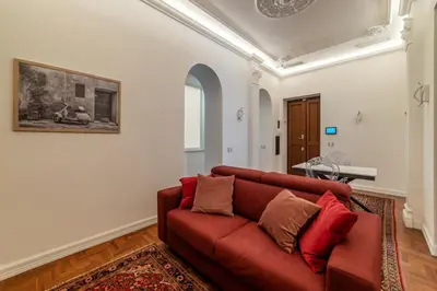 a living room with a red couch and a table at GuestHost - Rione Sallustiano Elegant Apartment in Rome