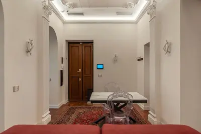 a living room with a chair and a door at GuestHost - Rione Sallustiano Elegant Apartment in Rome