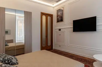 a bedroom with a bed and a flat screen tv at GuestHost - Rione Sallustiano Elegant Apartment in Rome