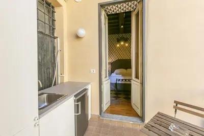a kitchen with a sink and a door to a bedroom at Pantheon Palazzo Nari Terrace #12 in Rome