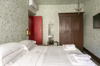 a large bed in a room with a red door at Pantheon Palazzo Nari Terrace #12 in Rome