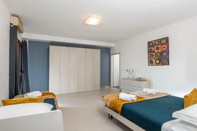 a bedroom with two beds and a blue and white wall at San Paolo Home in Rome