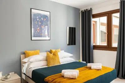 a bedroom with a bed with yellow and white pillows at San Paolo Home in Rome