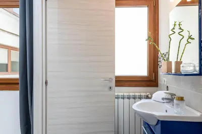 a bathroom with a sink and a shower door at San Paolo Home in Rome
